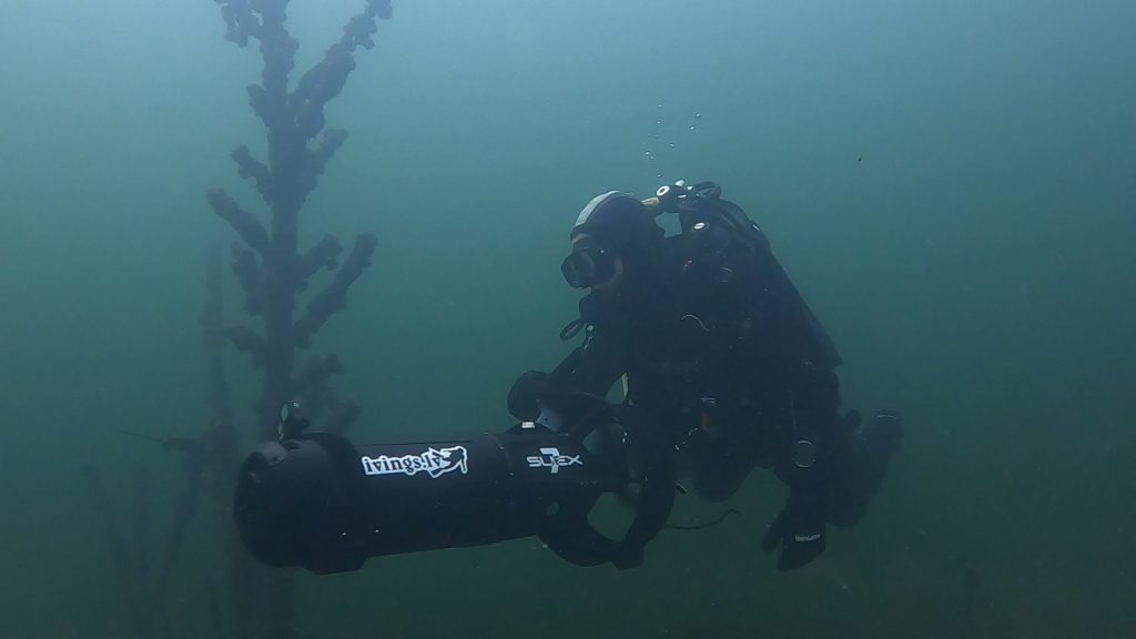 Scuba diving in a dry suit with a scooter